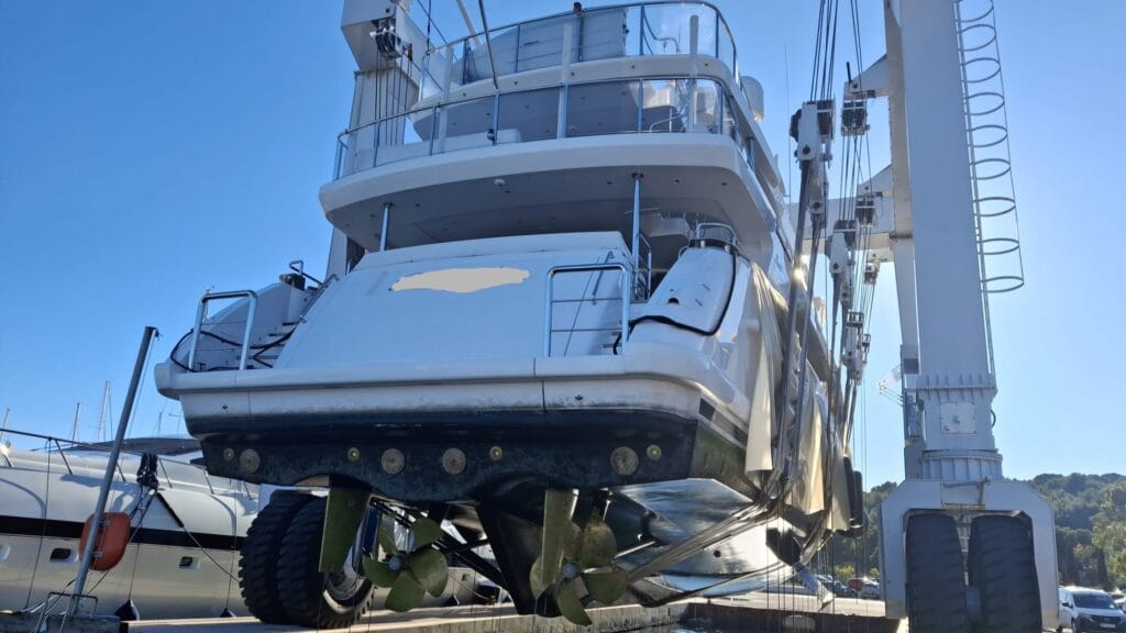 Yacht haul-out inspection showing propellers, shafts, and rudders during a marine survey